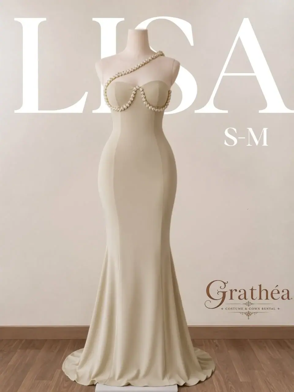 Lisa: A cream floor-length gown with a softly flared hem and pearl-like detailing sweeping around the bodice and over one shoulder.